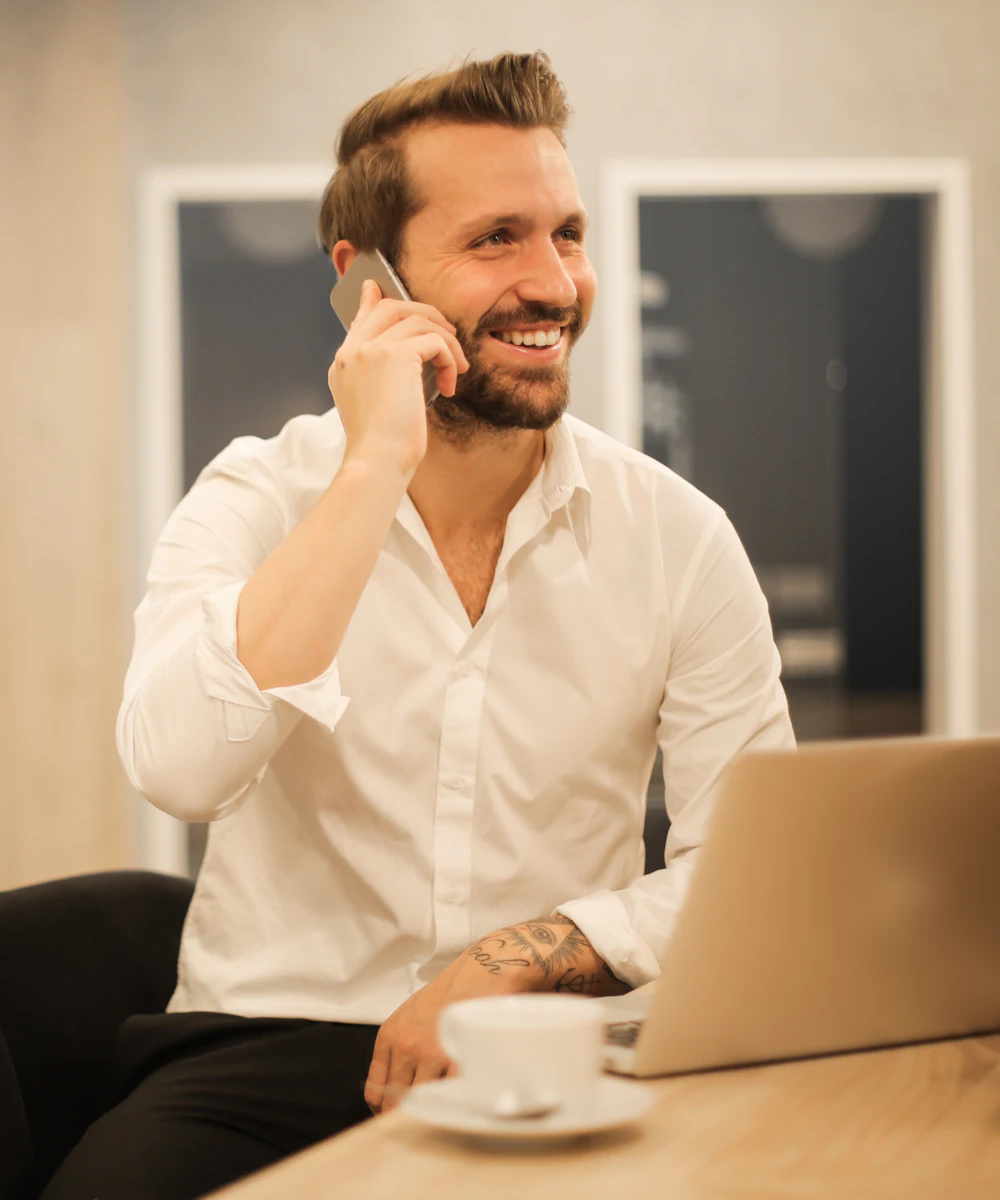 Business owner smiling on a phone call at his desk